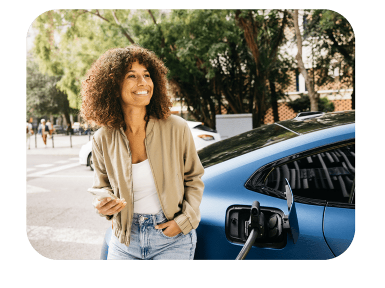 Femme qui recharge son véhicule. Elle utilise son téléphone avec l'application Charge+
